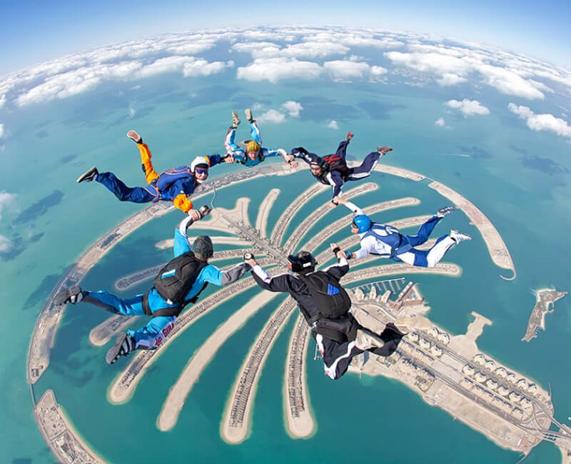 Six skydivers flying over the Islands.Jumeirah palm. Beautiful views of Dubai city